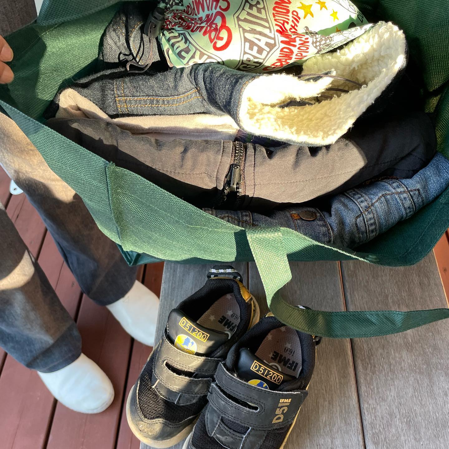 エコバッグいっぱいに持ち帰るこども服とスニーカー