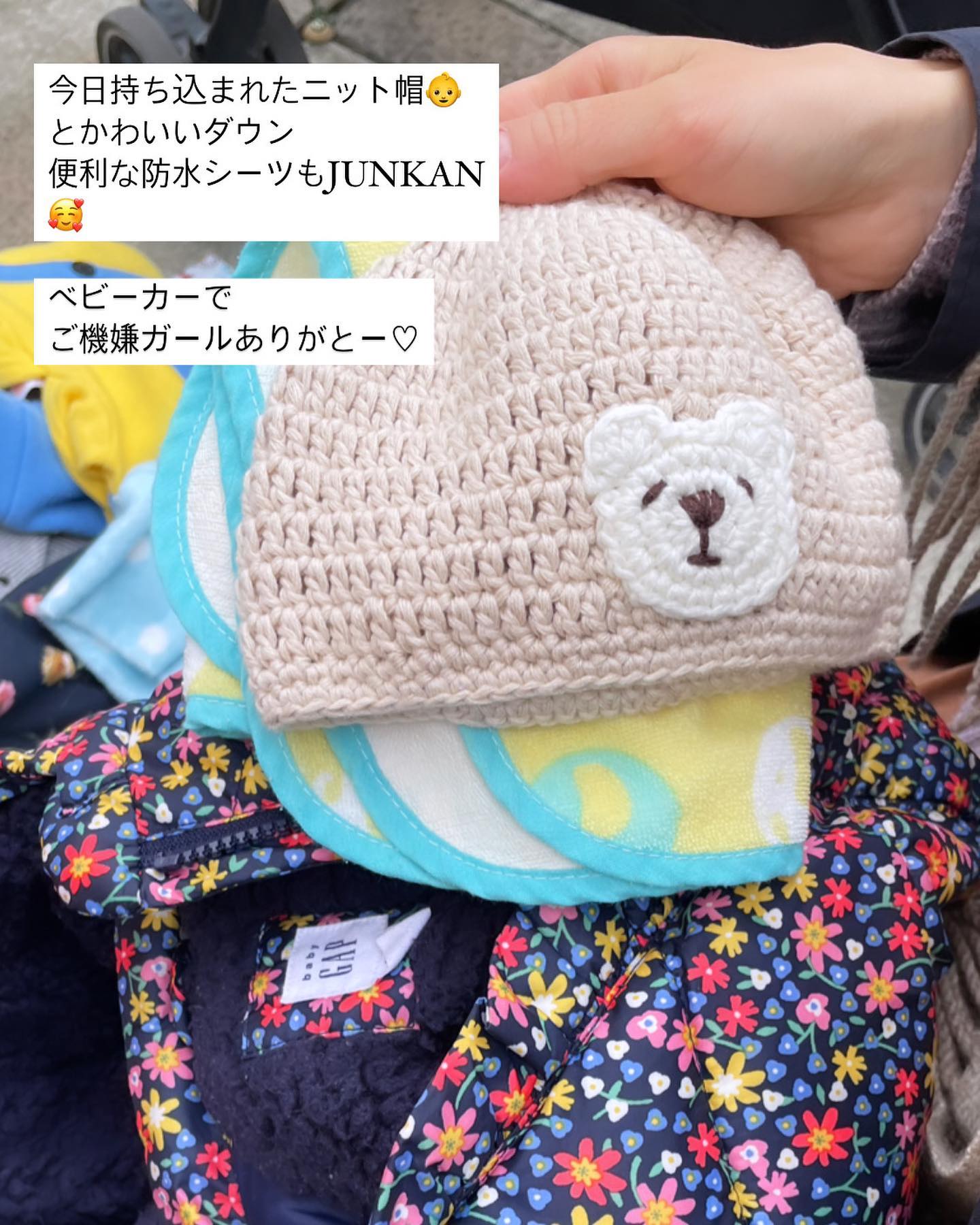 こども服交換会に持ち込まれたくまのニット帽とお花柄のベビーアイテム